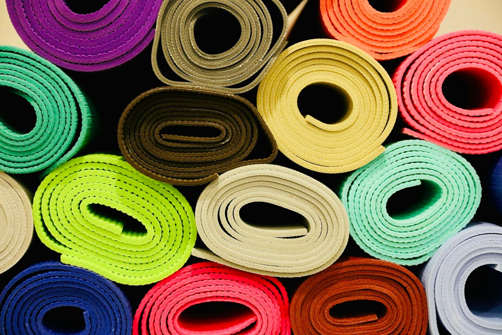 Rolls of foam sheet in a dozen colours stacked end-on, each spiral showing the thickness of the material