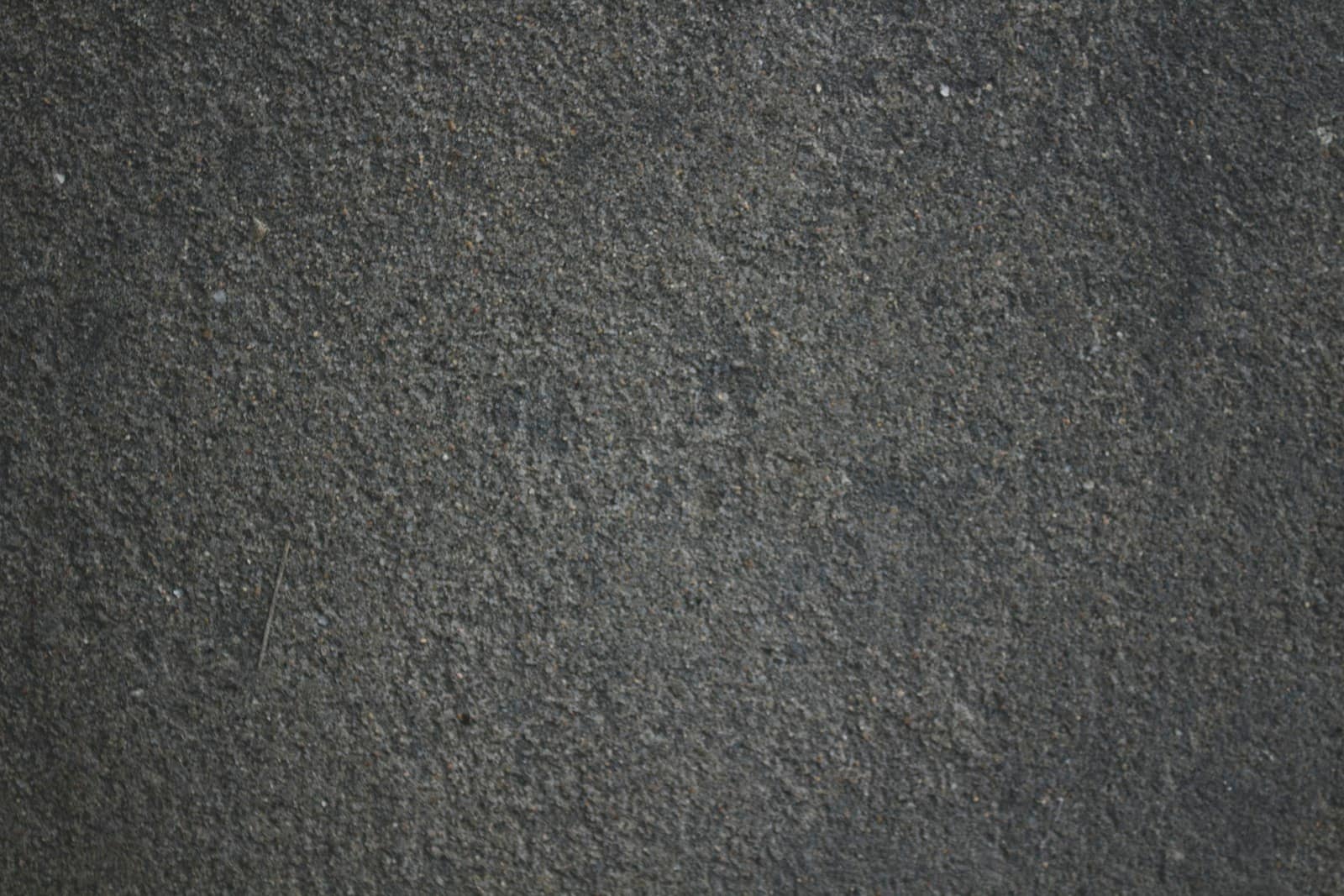 A dark, finely grained rubber surface under low light, its texture even across the frame